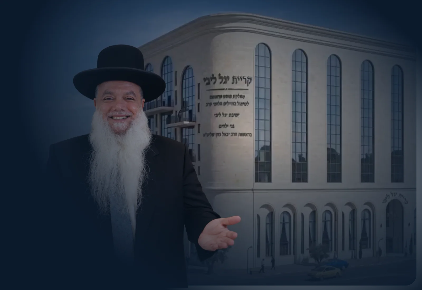 הרב יגאל כהן שליט"א מחייך ומצביע, ומאחוריו הדמיית הבניין של קרית יגל ליבי